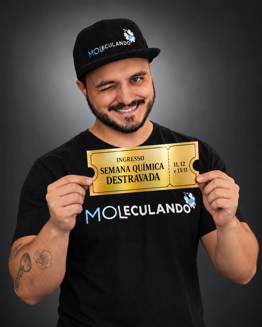 Prof. Lucas Moreno piscando e segurando com as duas mãos um ingresso dourado da Semana Química Destravada